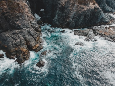 The rugged red cliffs of the Great Ocean Road meeting the crashing waves.