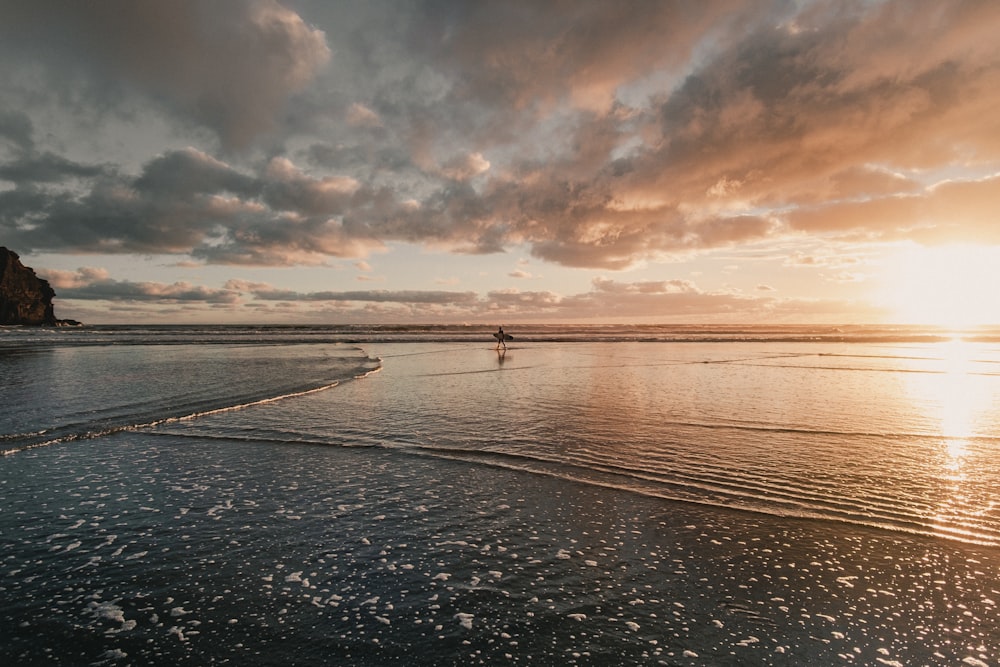 person in sea under cloudy sky during daytime