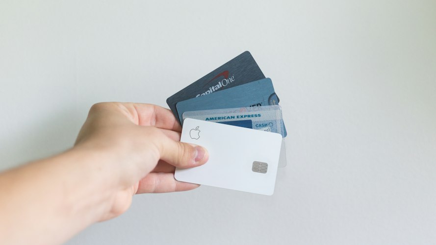 Close-up of a credit card and passport resting on a travel planning desk