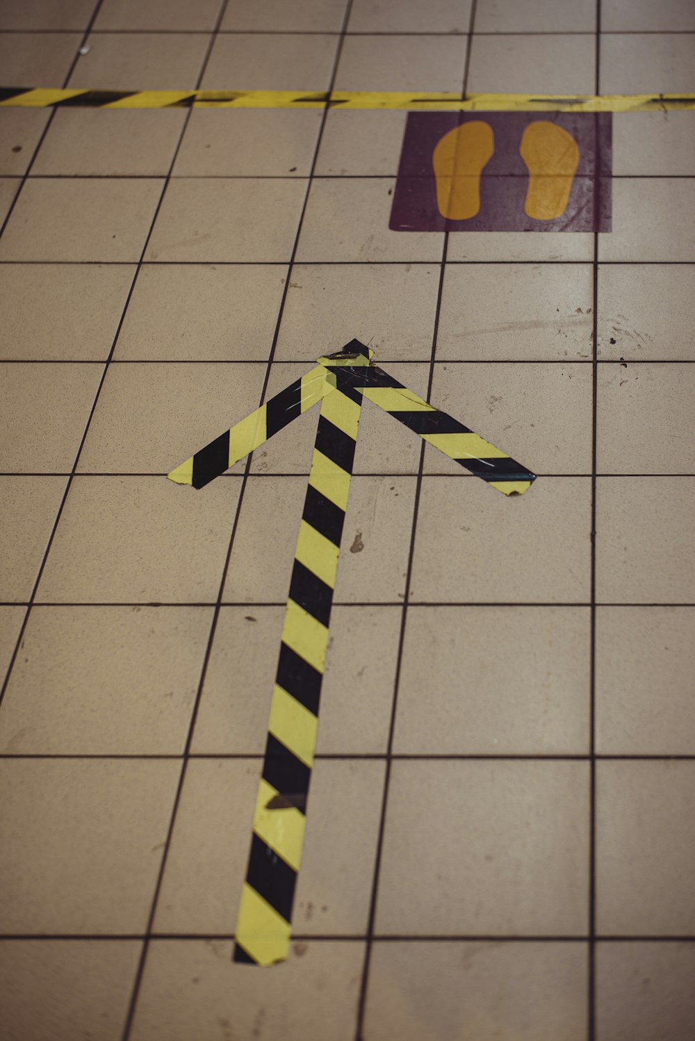 yellow and black cross on white floor tiles