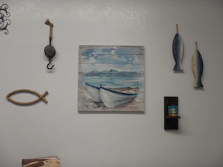3D printed framed artwork with marine motifs hanging on a light blue wall.