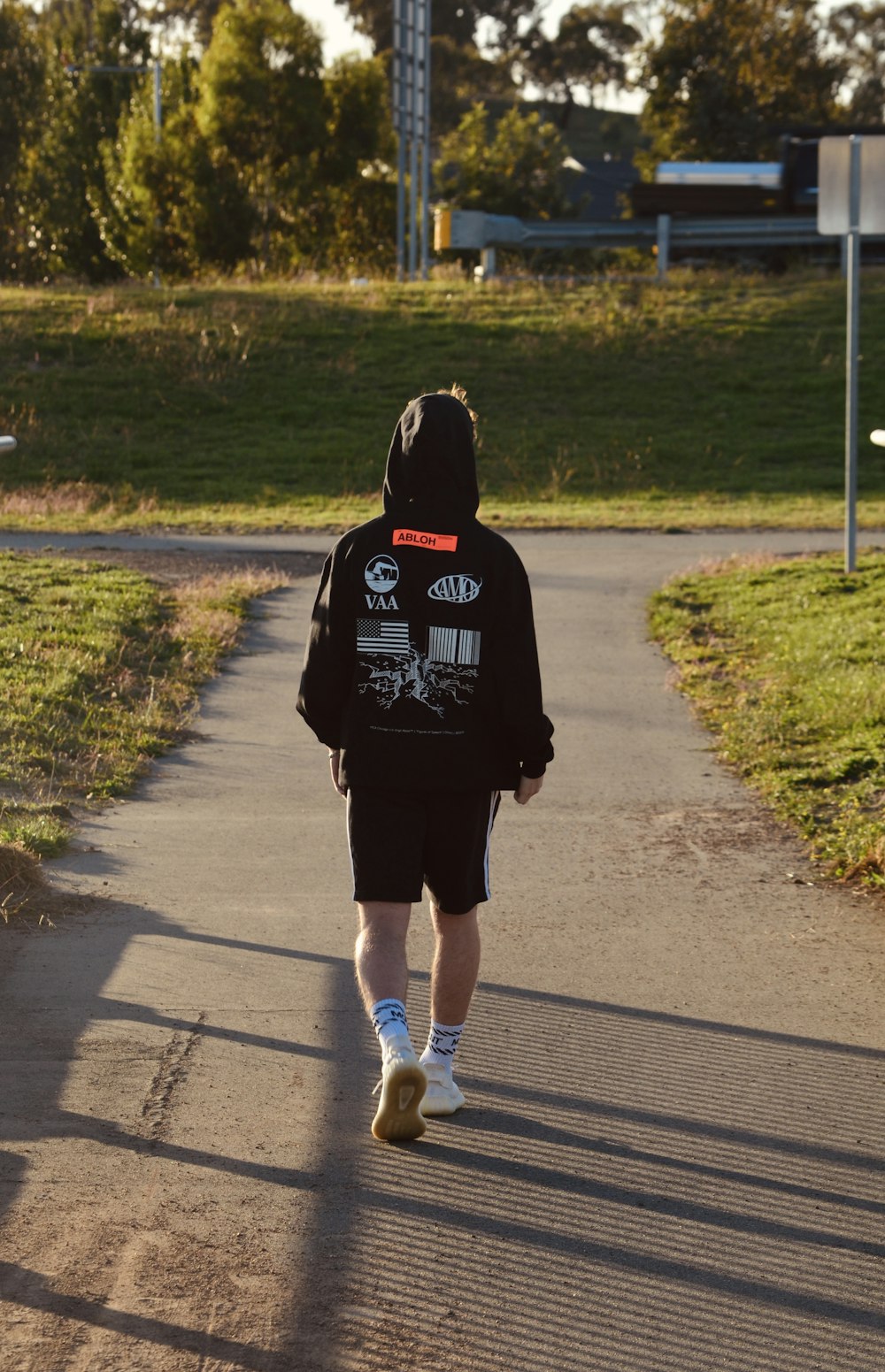 woman in black hoodie running on road during daytime