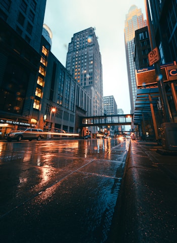 people walking on sidewalk near high rise buildings during daytime