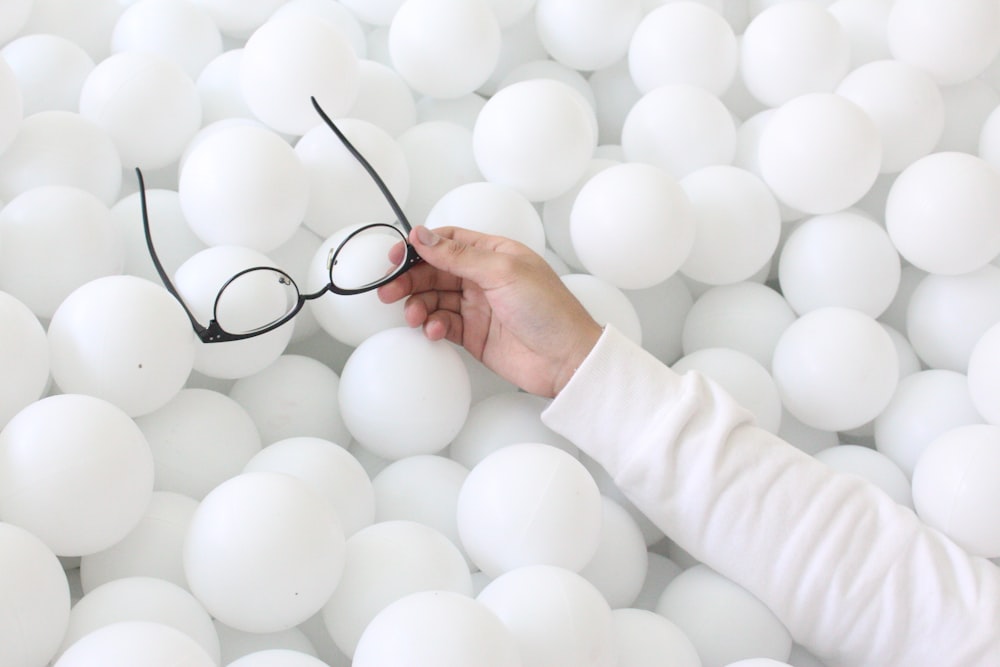 person holding white round ball