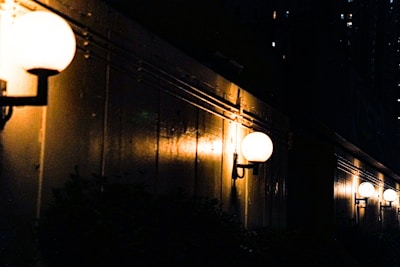 Savlyt flood lights mounted on an outdoor wall, illuminating a wide backyard with clear, powerful light.