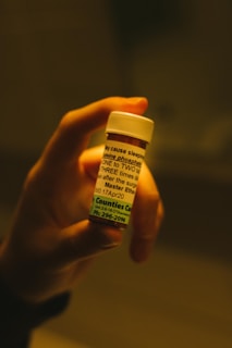person holding white and yellow plastic bottle