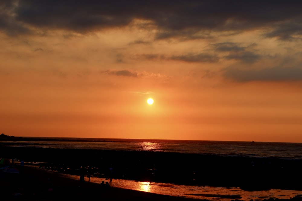 silhouette of people on beach during sunset