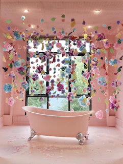 white ceramic bathtub with blue green and pink floral curtain