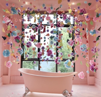 white ceramic bathtub with blue green and pink floral curtain
