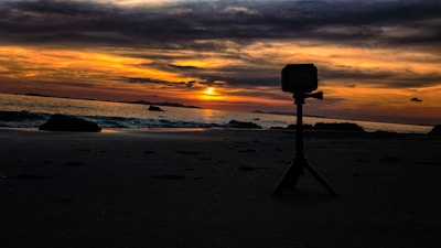 A vibrant photo of a travel influencer capturing a sunset on a tropical beach.