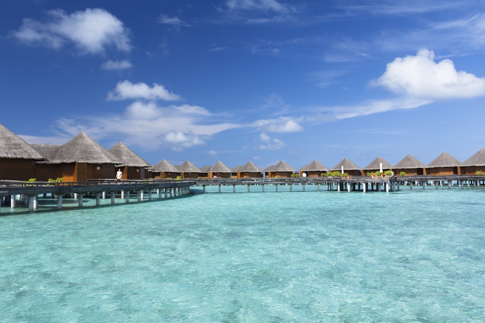 Braunes Holzhaus auf blauem Wasser unter blauem Himmel tagsüber