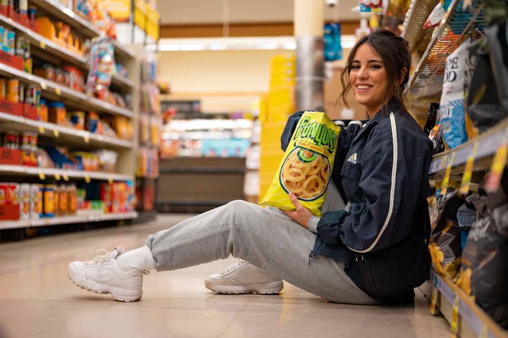 woman in black jacket and gray pants sitting on floor