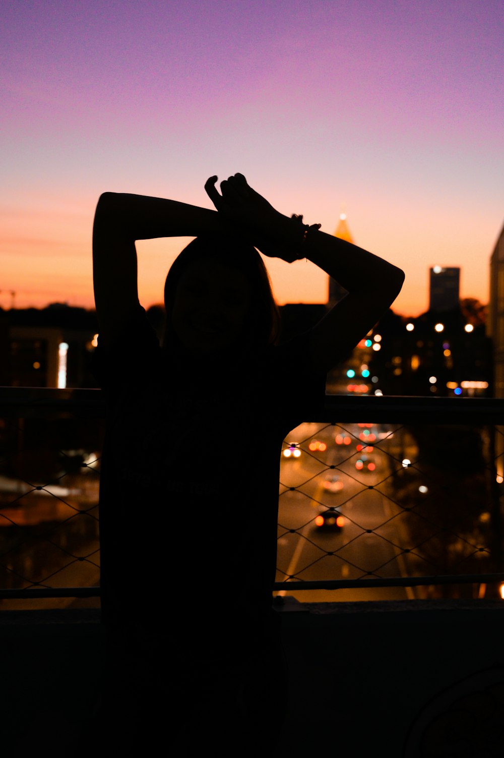 woman in black long sleeve shirt standing on the roof during sunset