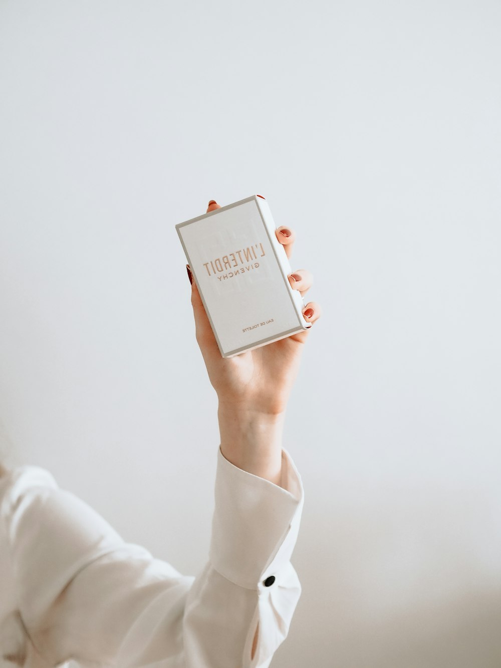 woman in white long sleeve shirt holding white box