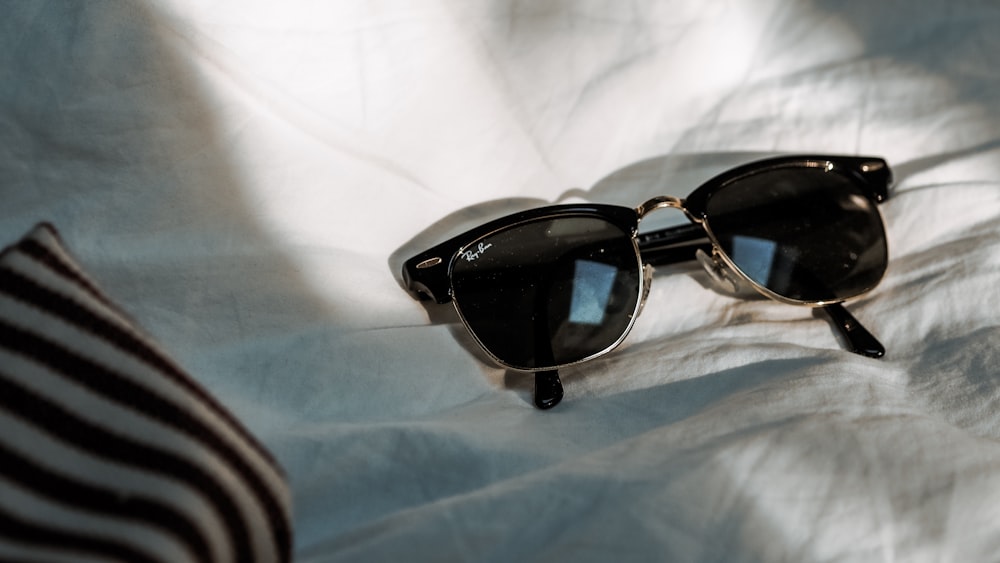 black framed sunglasses on white textile