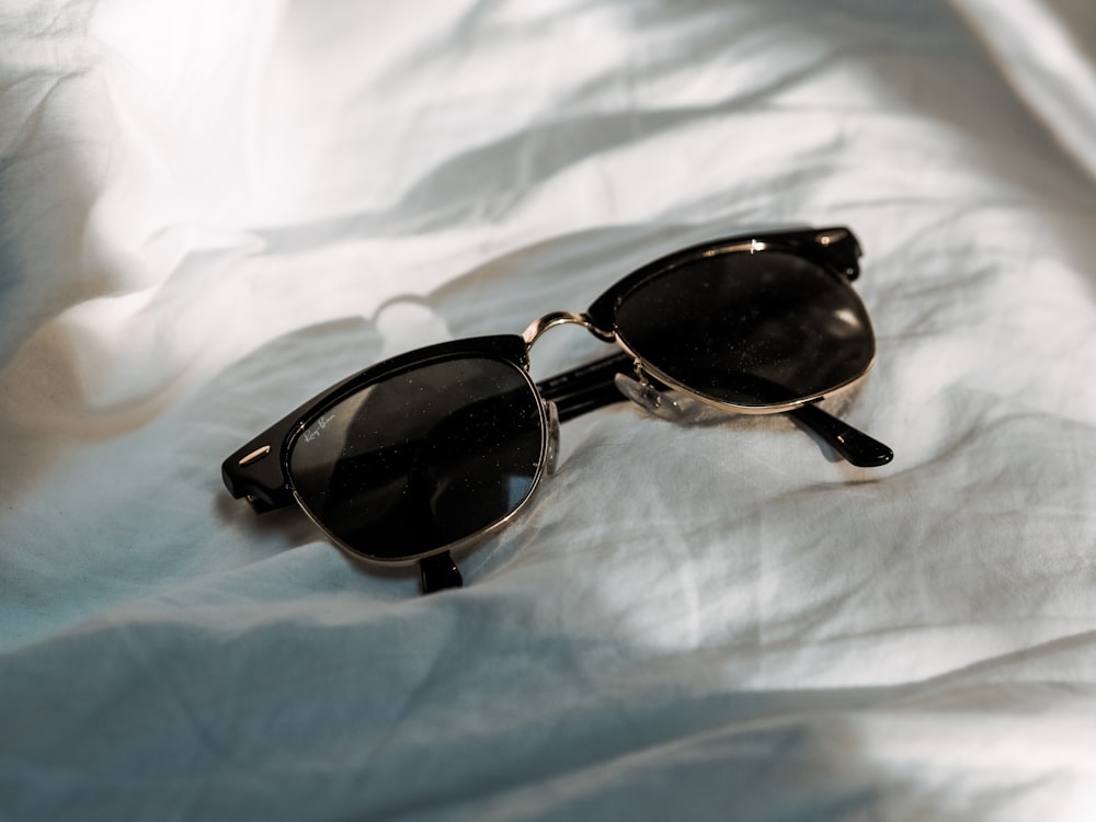 black framed sunglasses on white textile