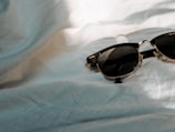 Stylish sunglasses resting on a white table with soft lighting.
