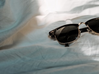 A vibrant shot of sunglasses resting on a dark wooden table with soft lighting