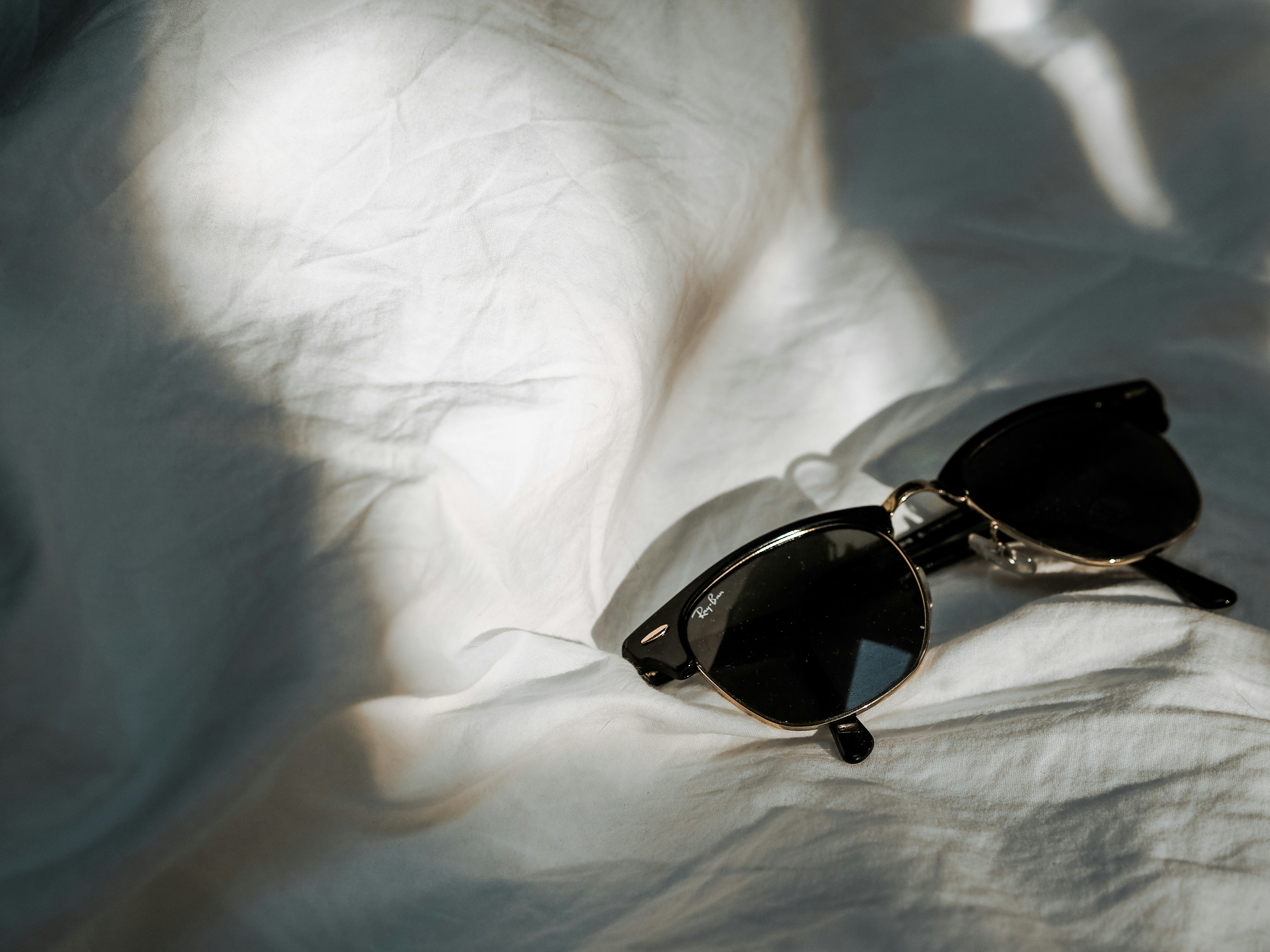 black and brown framed sunglasses on white textile, Sunglasses