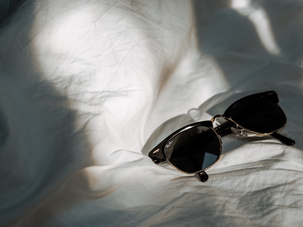 black and brown framed sunglasses on white textile