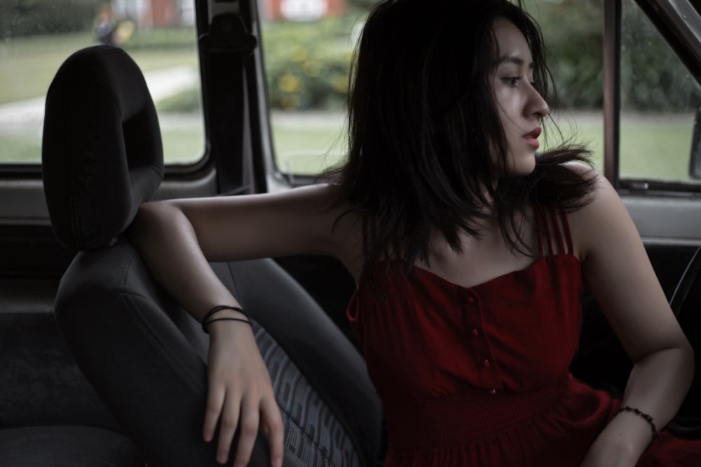 woman in red tank top sitting on car seat