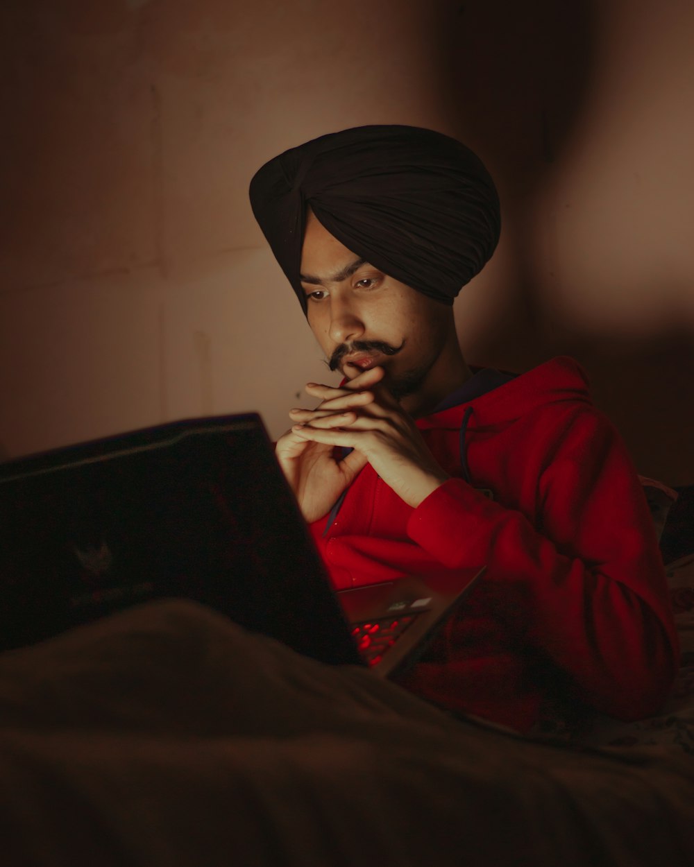 woman in red hoodie holding black laptop computer