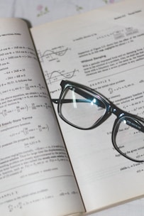 An open book with financial graphs and a calculator on a desk.