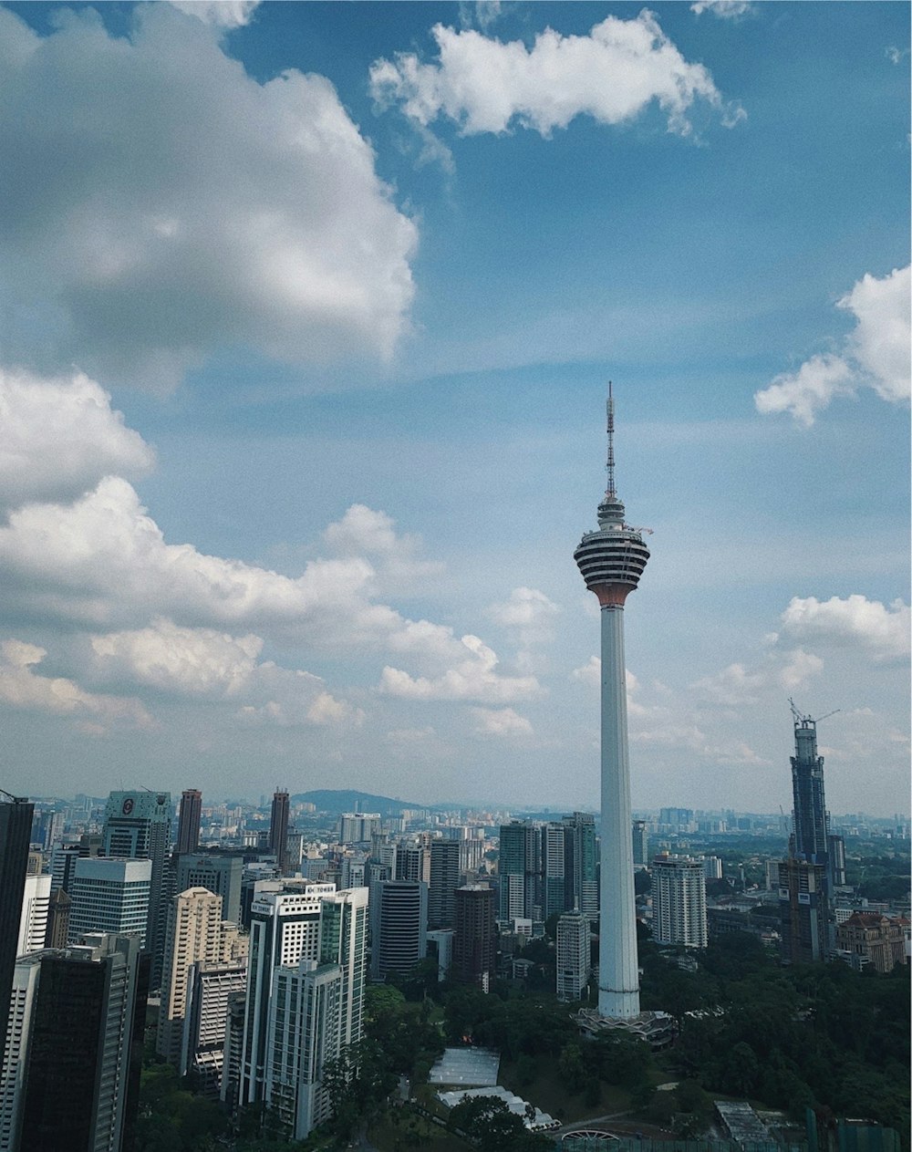 white and black tower under white clouds and blue sky during daytime