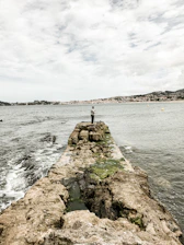 gray concrete dock on body of water under cloudy sky during daytime