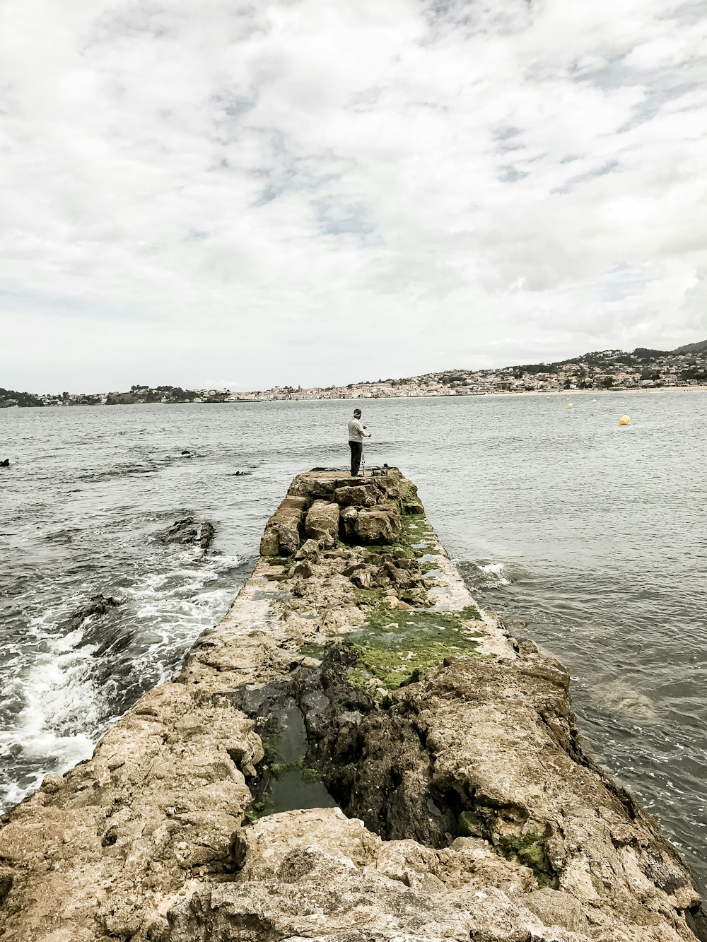 gray concrete dock on body of water under cloudy sky during daytime