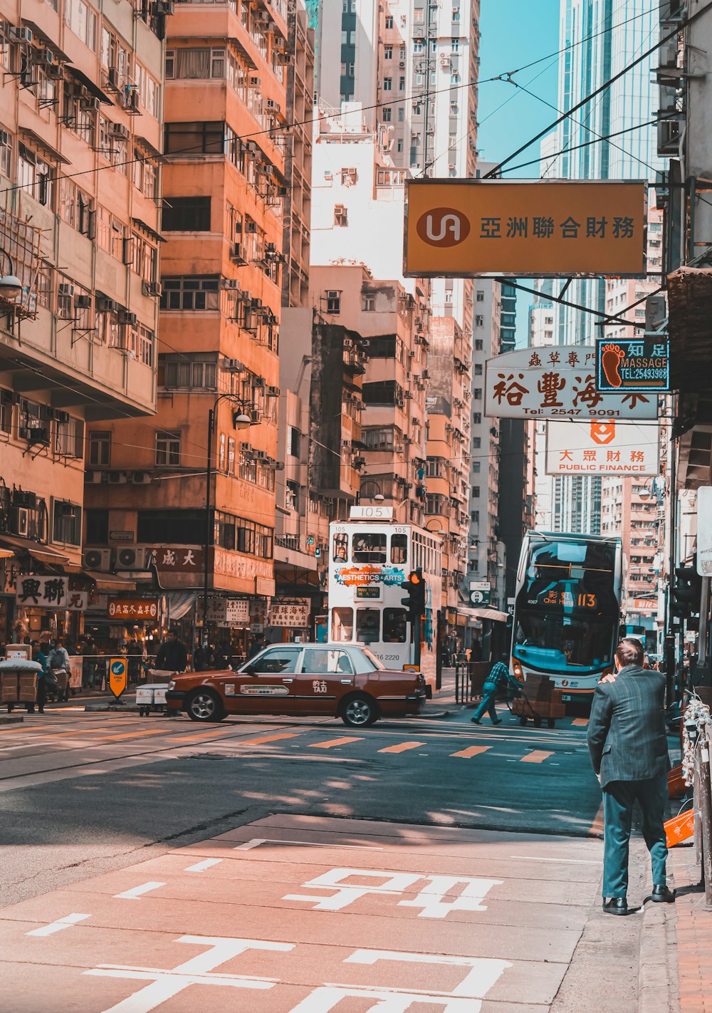 man in black jacket and blue denim jeans walking on pedestrian lane during daytime