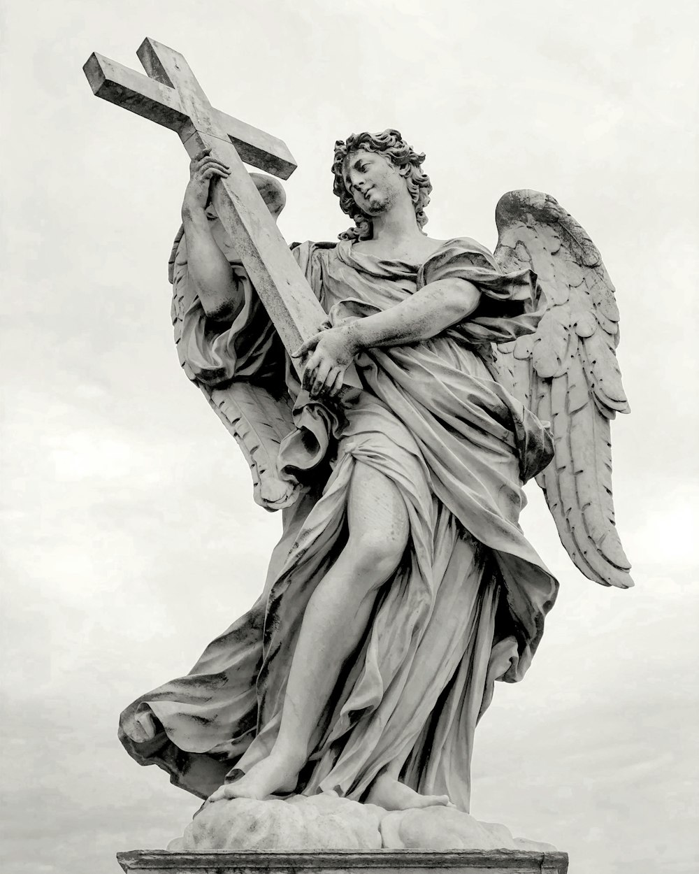 statua dell'angelo sotto il cielo bianco durante il giorno