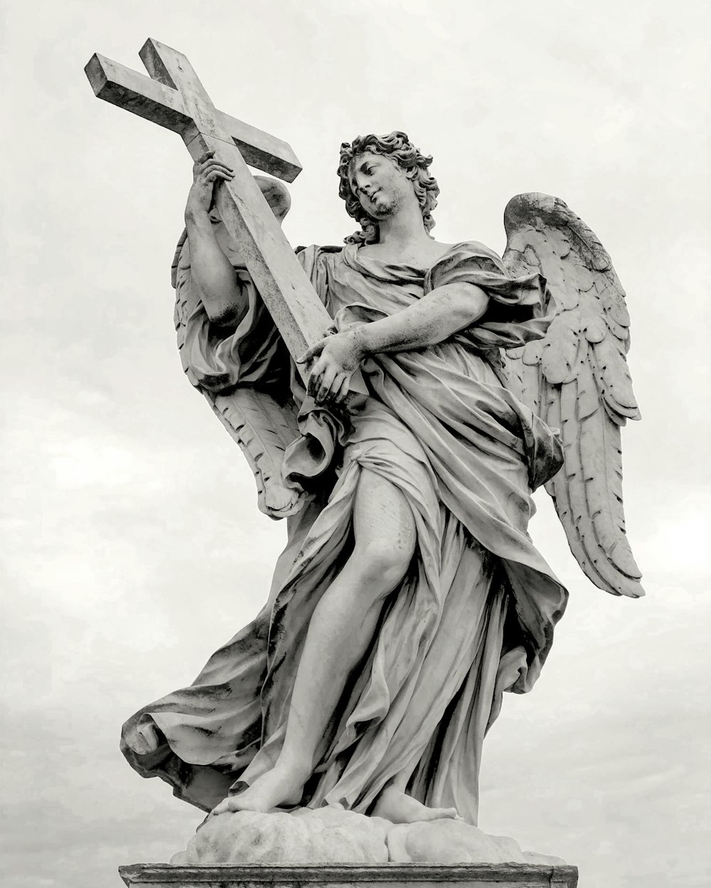 Estatua del ángel bajo el cielo blanco durante el día