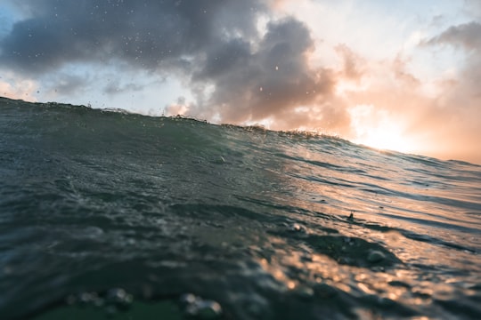 ocean waves under white clouds during daytime in Te Arai New Zealand