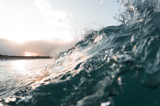 water waves under blue sky during daytime in Te Arai New Zealand