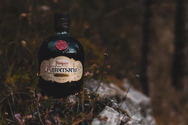 Glass bottle of amber-colored mead with wildflowers in the background.