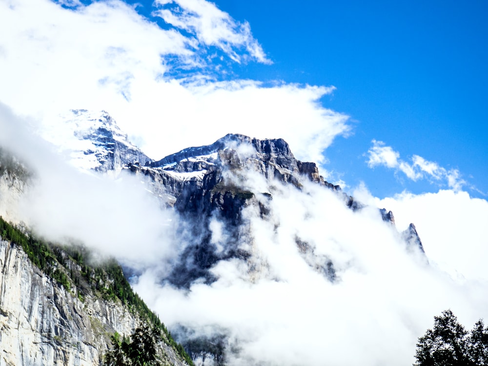 white clouds over snow covered mountain