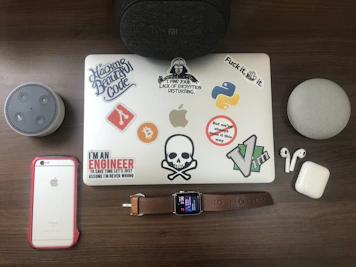 Various tech gadgets and electronics like headphones, smartwatches, and portable speakers displayed on a minimalist desk.