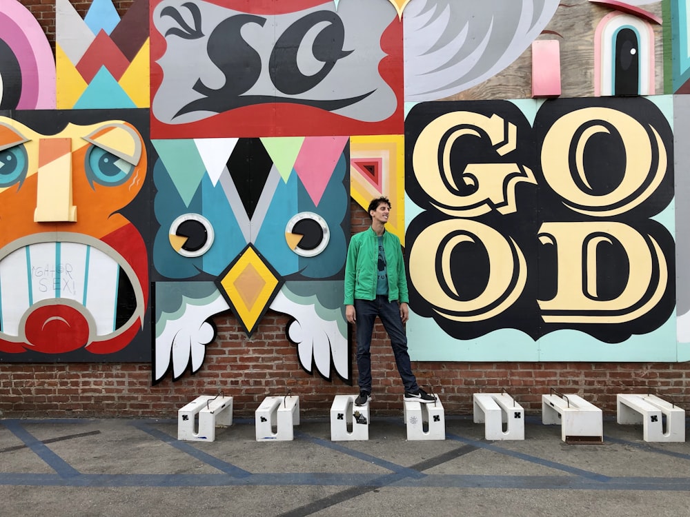 Frau in blauer Jacke steht an der Wand mit Graffiti