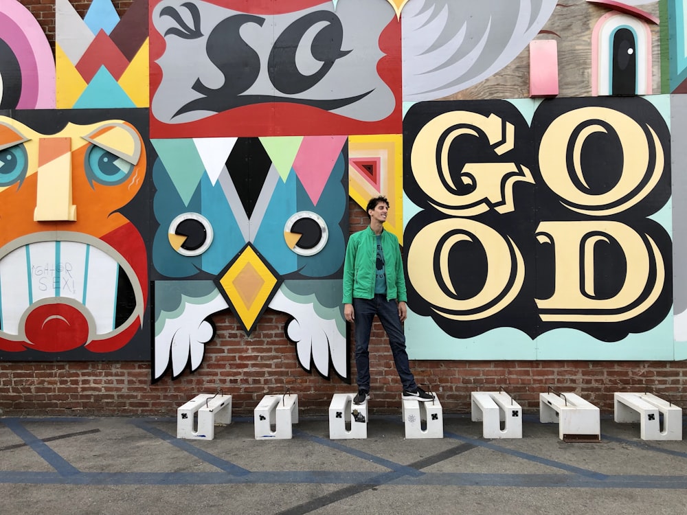 woman in blue jacket standing beside wall with graffiti