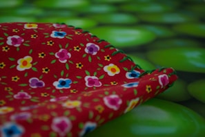 A colorful spring blouse laid out on a floral background.
