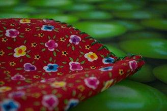 A colorful spring blouse laid out on a floral background.