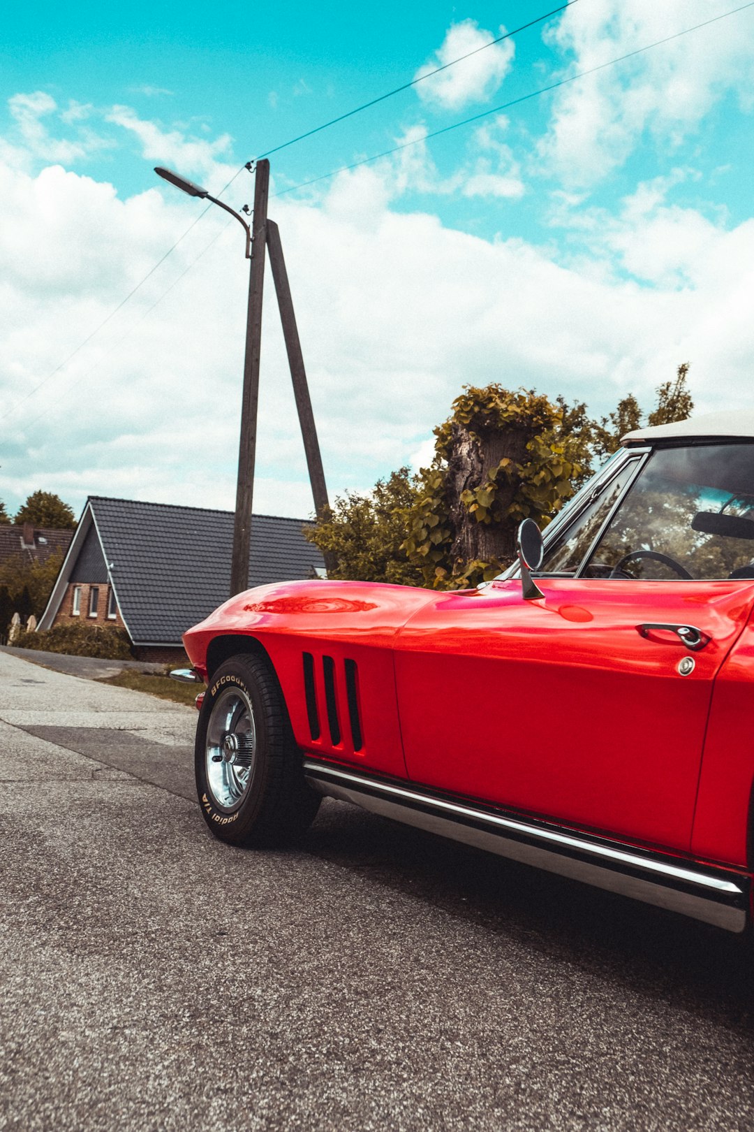 red convertible car parked on gray asphalt road during daytime