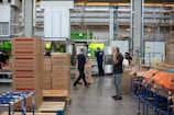 man in gray shirt standing beside brown cardboard boxes