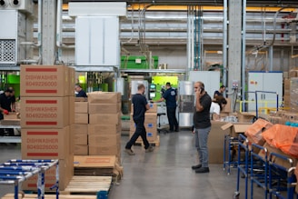 man in gray shirt standing beside brown cardboard boxes