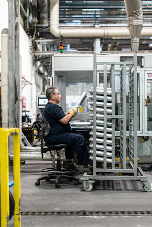 Warehouse worker inspecting iron items ready for wholesale shipment.