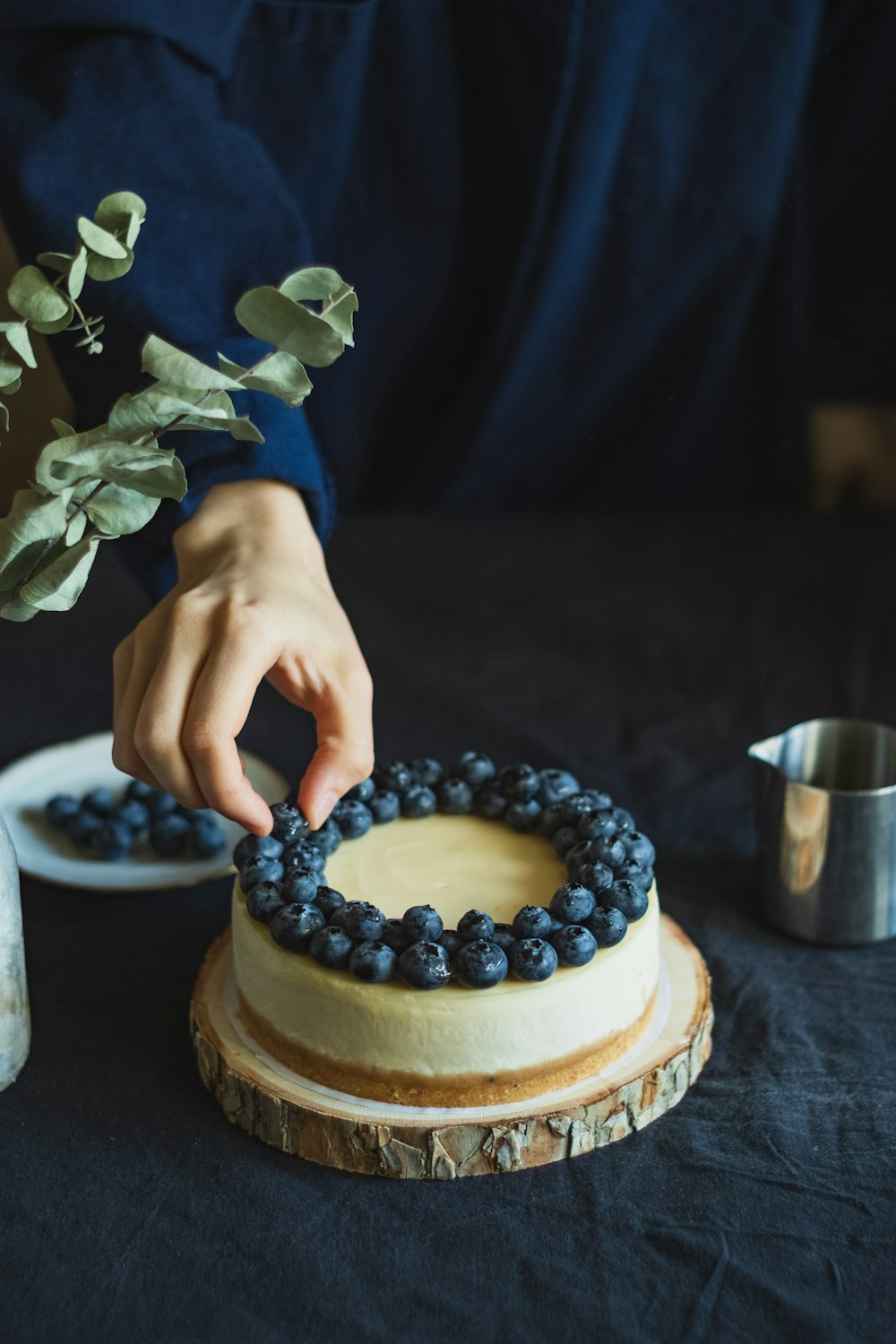 person holding cake with white icing and blue icing