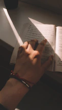 Close-up of a colorful gospel bracelet resting on an open Bible with soft morning light.