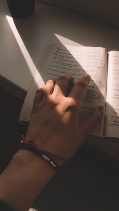 Close-up of a colorful gospel bracelet resting on an open Bible with soft morning light.
