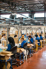 A factory worker carefully inspecting products on an assembly line to ensure quality.